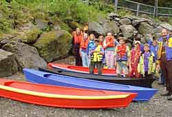 basis-schoolkinderen met hun zelfgebouwde kano's.